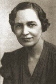 Margaret Young Stafford, in later years; short waved dark hair, and a stylish dark dress with sleeves gathered high and a V-neckline